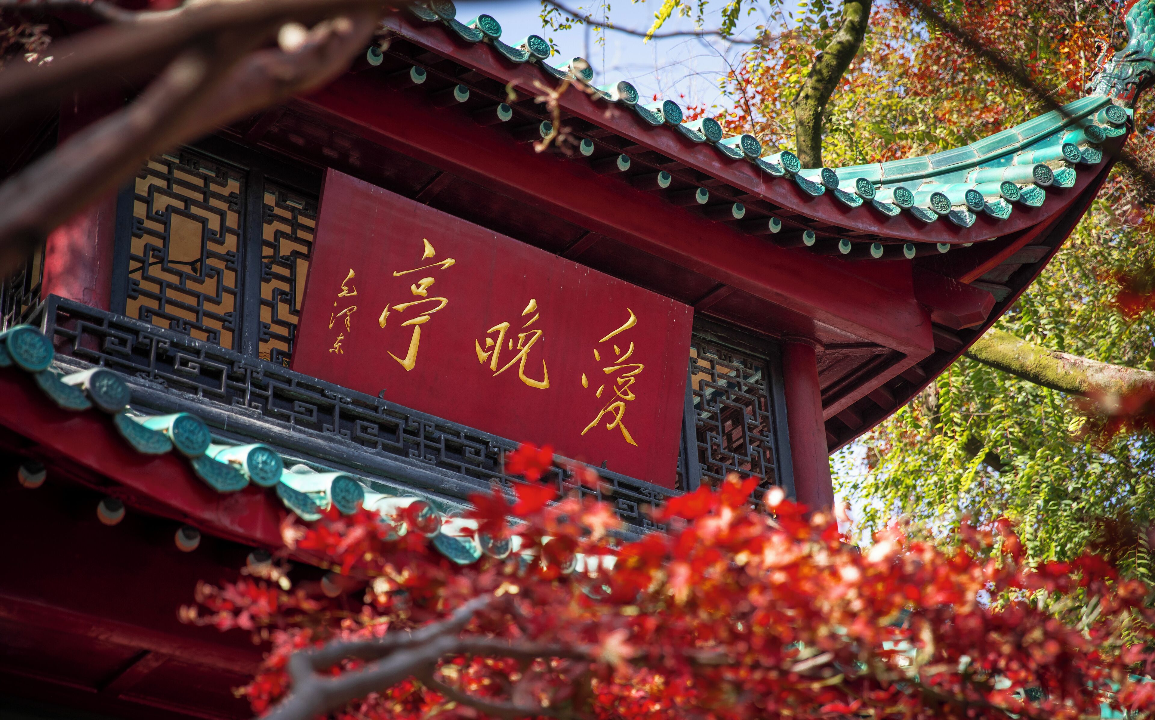 A traditional Chinese building with a red roof and golden Chinese characters.