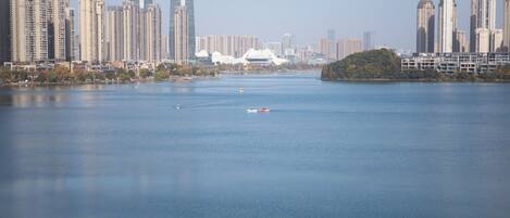 Un río con un paisaje urbano al otro lado, incluyendo rascacielos y una estructura blanca distintiva.