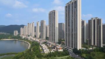 A high-rise residential area with multiple apartment buildings, a road, and a lake.