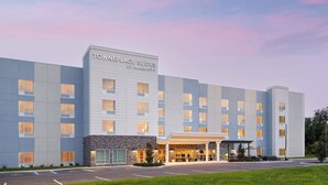A modern hotel with a sign reading "TownePlace Suites by Marriott" and a covered entrance area.