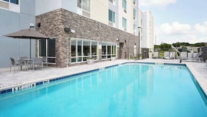 A swimming pool with lounge chairs and a patio area.