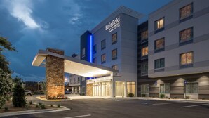 A multi-story hotel with a prominent entrance canopy, a stone pillar, and a Marriott logo.