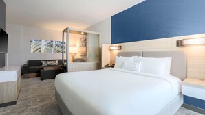 A hotel room with a large bed, a sofa, a desk, and a mirror. - SpringHill Suites by Marriott San Jose Fremont (Fremont)