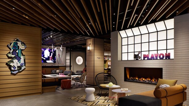 A modern hotel lobby with a fireplace, seating area, and a Playon sign. - Moxy Kyoto (Kyoto)