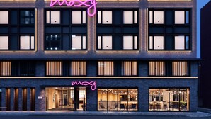 A modern hotel with a neon sign, large windows, and a well-lit entrance. - Moxy Kyoto (Kyoto)