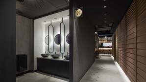 A modern bathroom with a vanity, mirrors, and a sink. - Moxy Kyoto (Kyoto)
