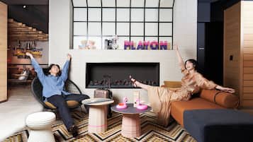 A modern living room with a fireplace, two sofas, a coffee table, and a patterned rug.