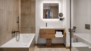 Un baño moderno con una bañera independiente, un tocador con espejo y una zona de ducha.