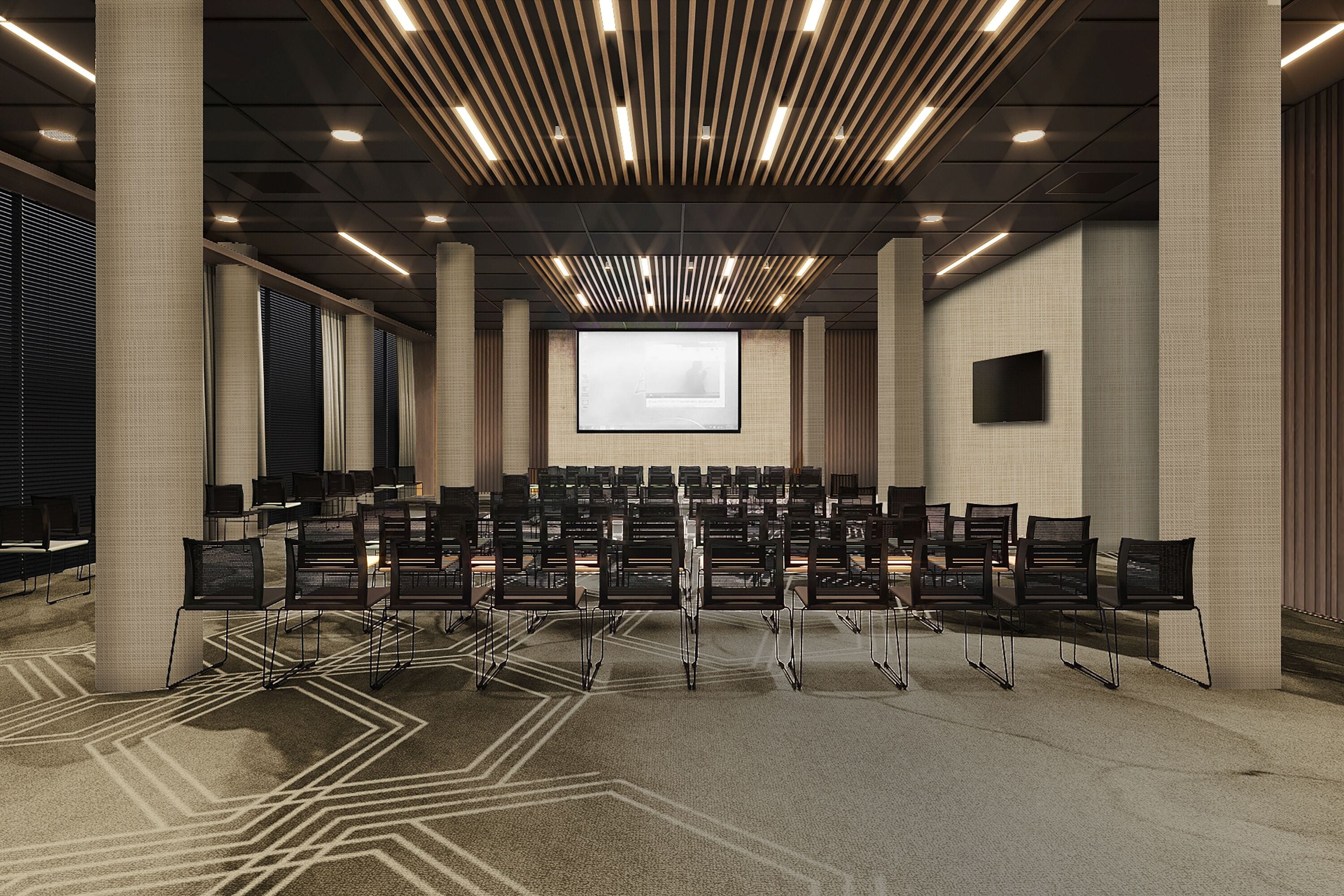 A conference room with rows of chairs, a large screen, and a modern ceiling design.