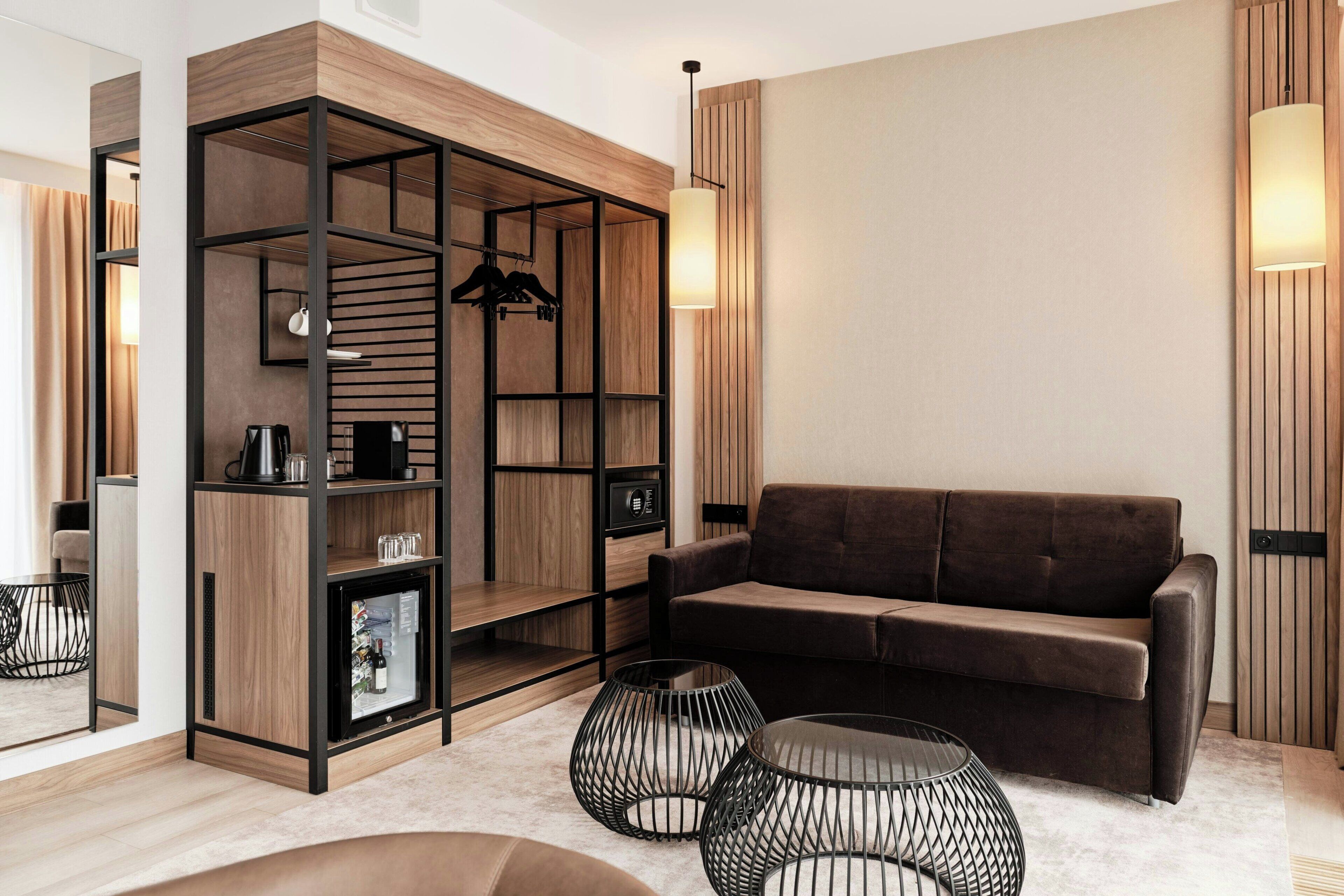 A modern living room with a sectional sofa, a built-in wooden shelving unit, and a glass coffee table.