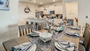 A modern kitchen with white cabinets, a central island, and pendant lighting. - WIR Free Pool Heat/Grill Use, Walk to Lazy River (Four Corners)