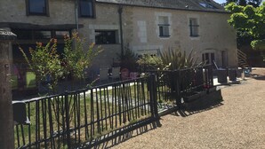 A two-story building with a stone facade, multiple windows, and a gravel driveway. - LOFT P'TITE POMME with SPA (Azay-le-Rideau)