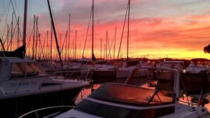 A marina with multiple boats docked during sunset.