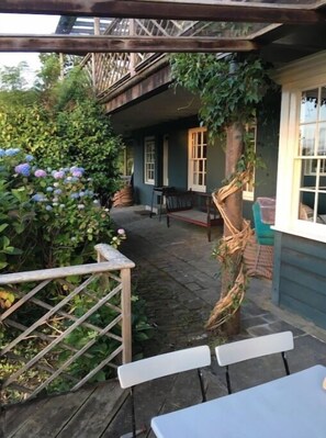 Relax in this charming outdoor seating area with a pergola overhead, perfect for dining or socializing.