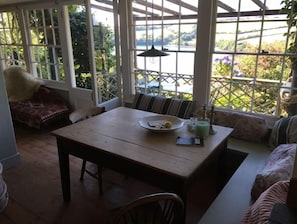 Enjoy a serene retreat with a view of lush greenery and a body of water from this room's large windows.
