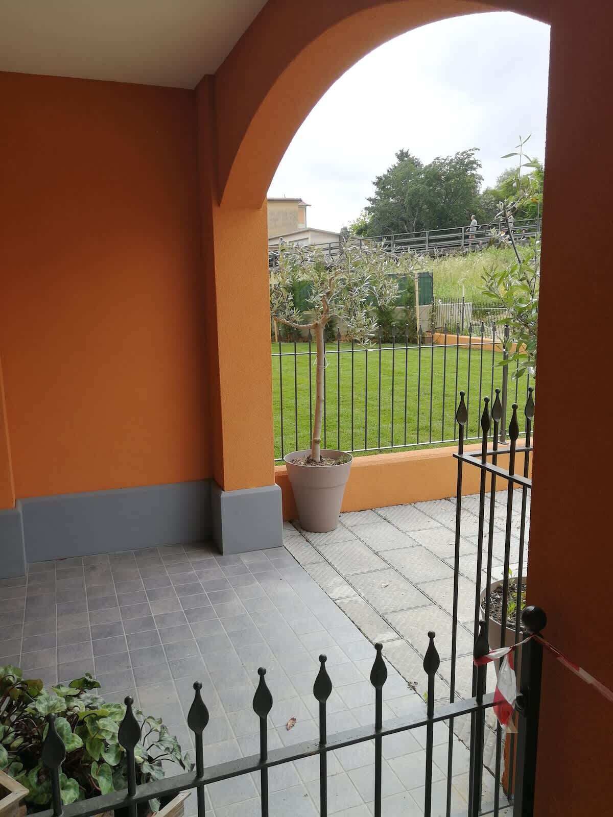 Ein Balkon mit Blick auf eine Wiese und einen Zaun.