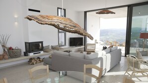 Ein modernes Wohnzimmer mit einer Couch, einem Fernseher und einem Essbereich mit Stühlen und einem Tisch.