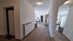 A spacious hallway with a dining area in the background, a radiator on the left, and a door on the left side. - Levanto Condo w/ Terrace, Near Beach & Train  P (Levanto)