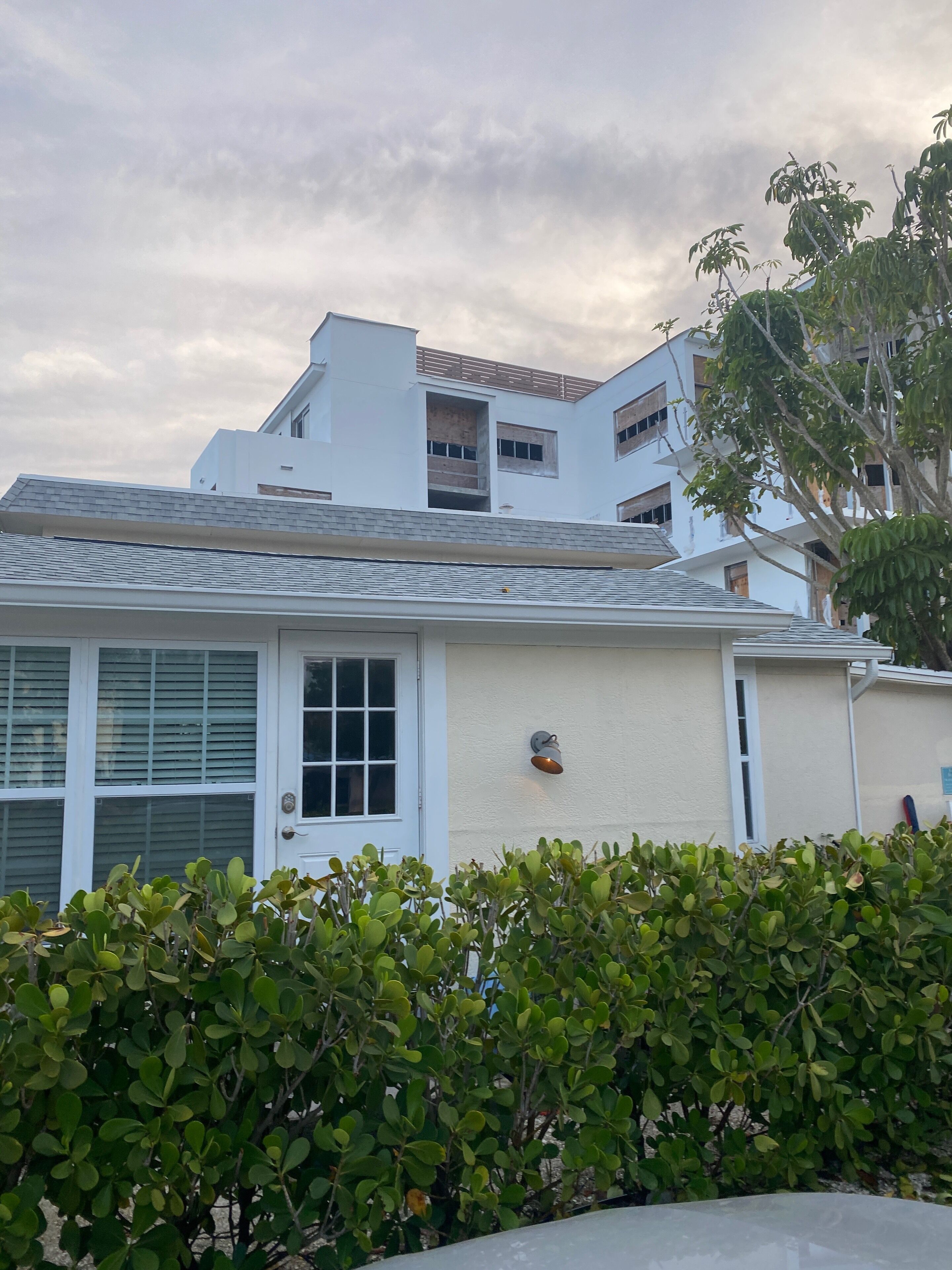 A residential building with a white exterior, a visible door, and a small window.