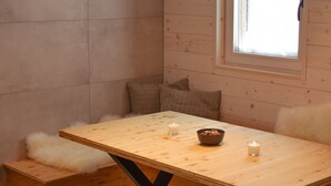 A wooden dining table with a bowl and candles, a window with blinds, and a fluffy white cushion. - Private Cottage - Active Regeneration and Relaxing Hollidays (Stahovica)