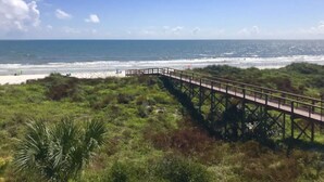 A beach with a wooden boardwalk leading to the shore. - Oceanfront, Pet-Friendly Condo with Private Balcony! (St. Augustine)