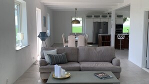 Una sala moderna con sofá, mesa de centro y comedor con mesa y sillas.