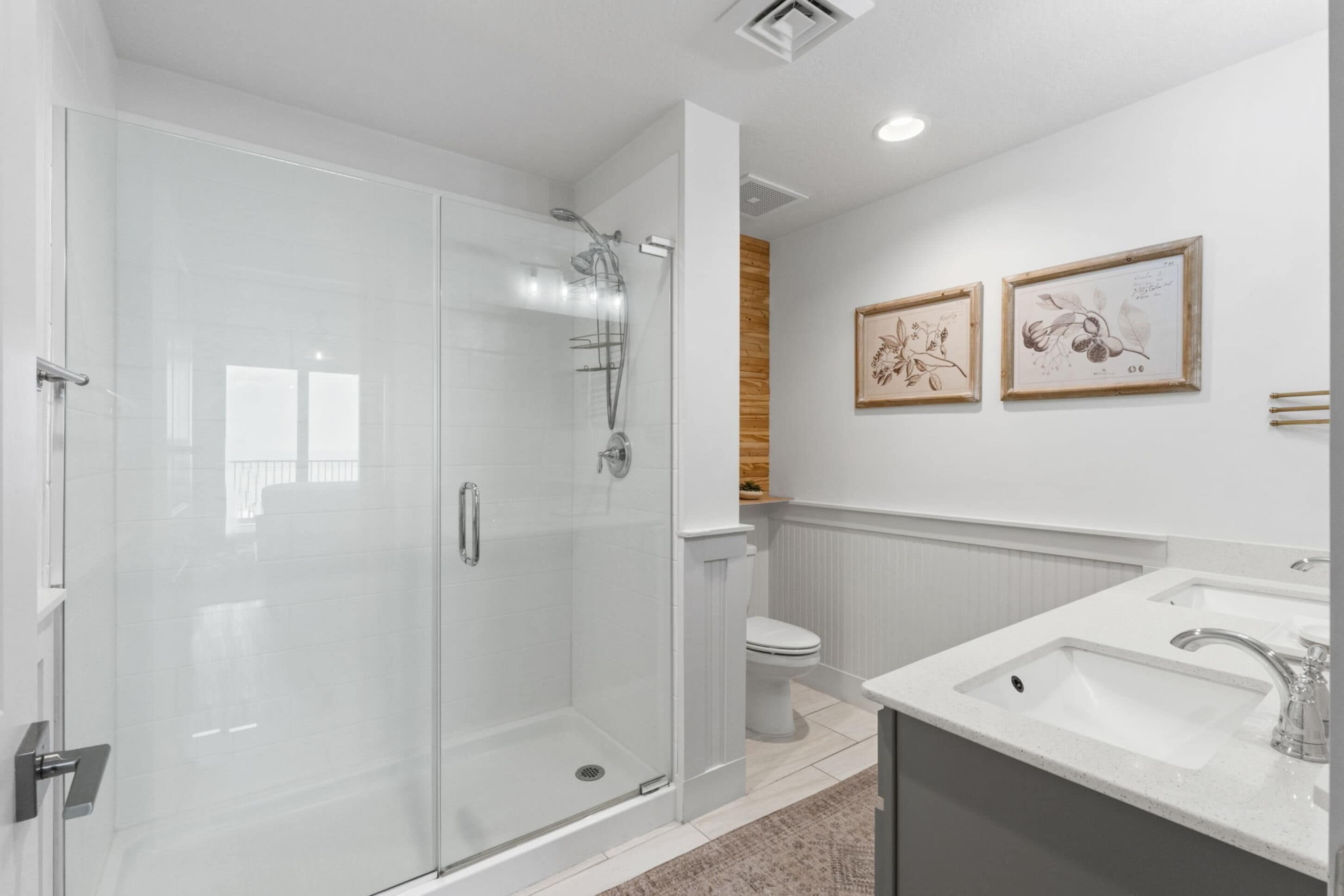 Un baño moderno con ducha de vidrio, inodoro y lavamanos.