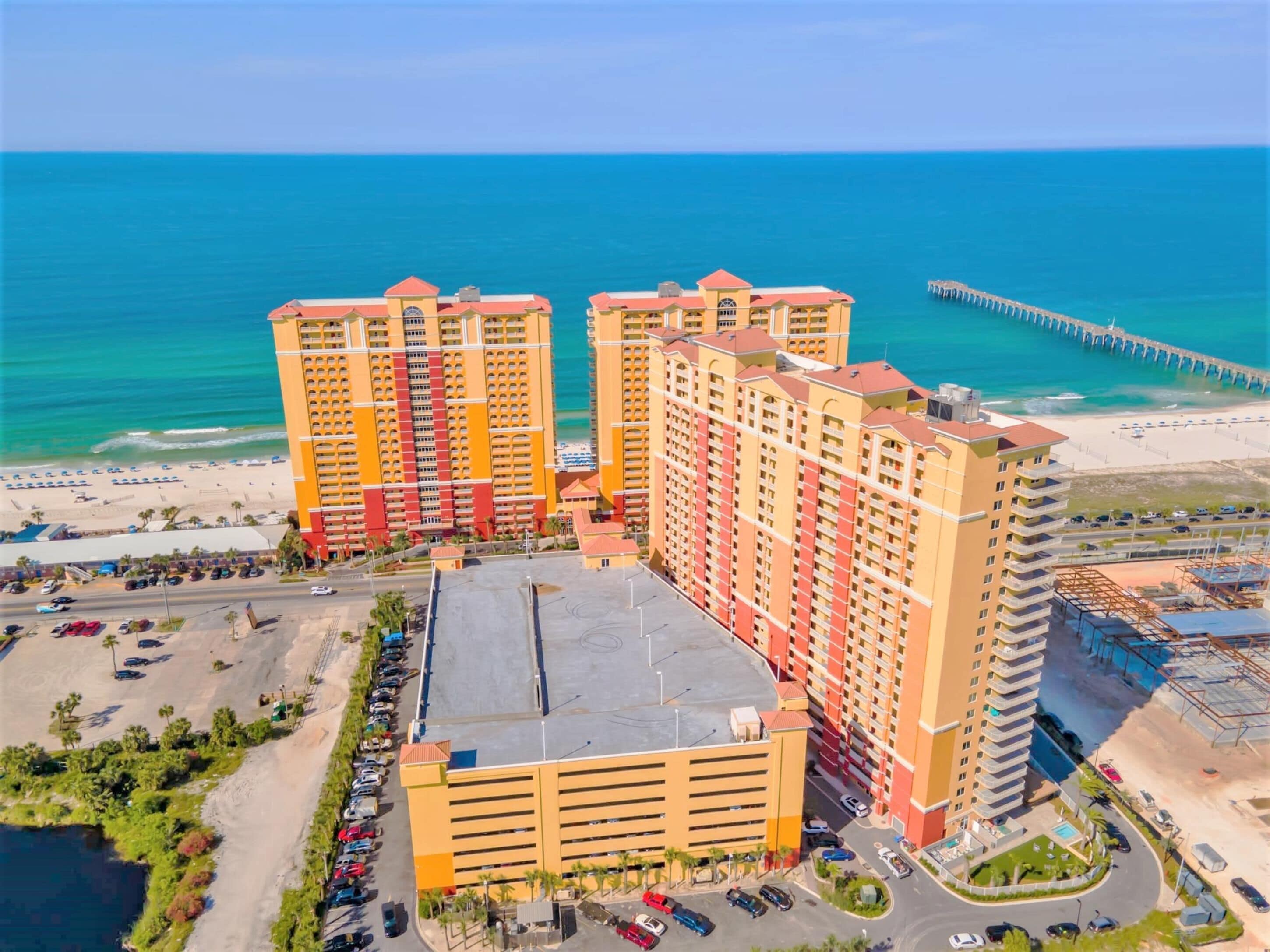Un hotel moderno de muchas plantas, con estacionamiento y vista al mar.