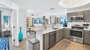 A modern kitchen with stainless steel appliances, a large island, and a view of the city.