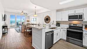 A modern kitchen with white cabinetry, a built-in oven, and a microwave.