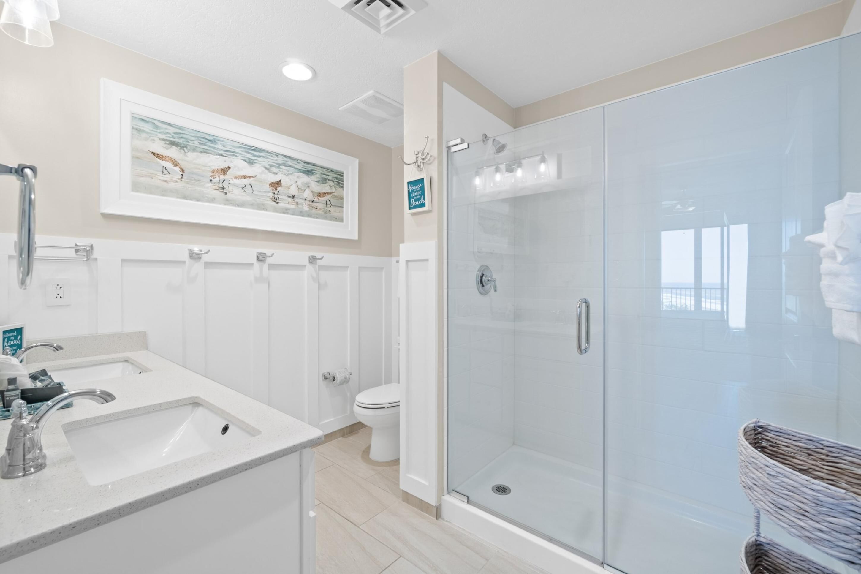 Ein modernes Badezimmer mit Duschkabine aus Glas, Waschbecken mit Spiegel und Toilette.