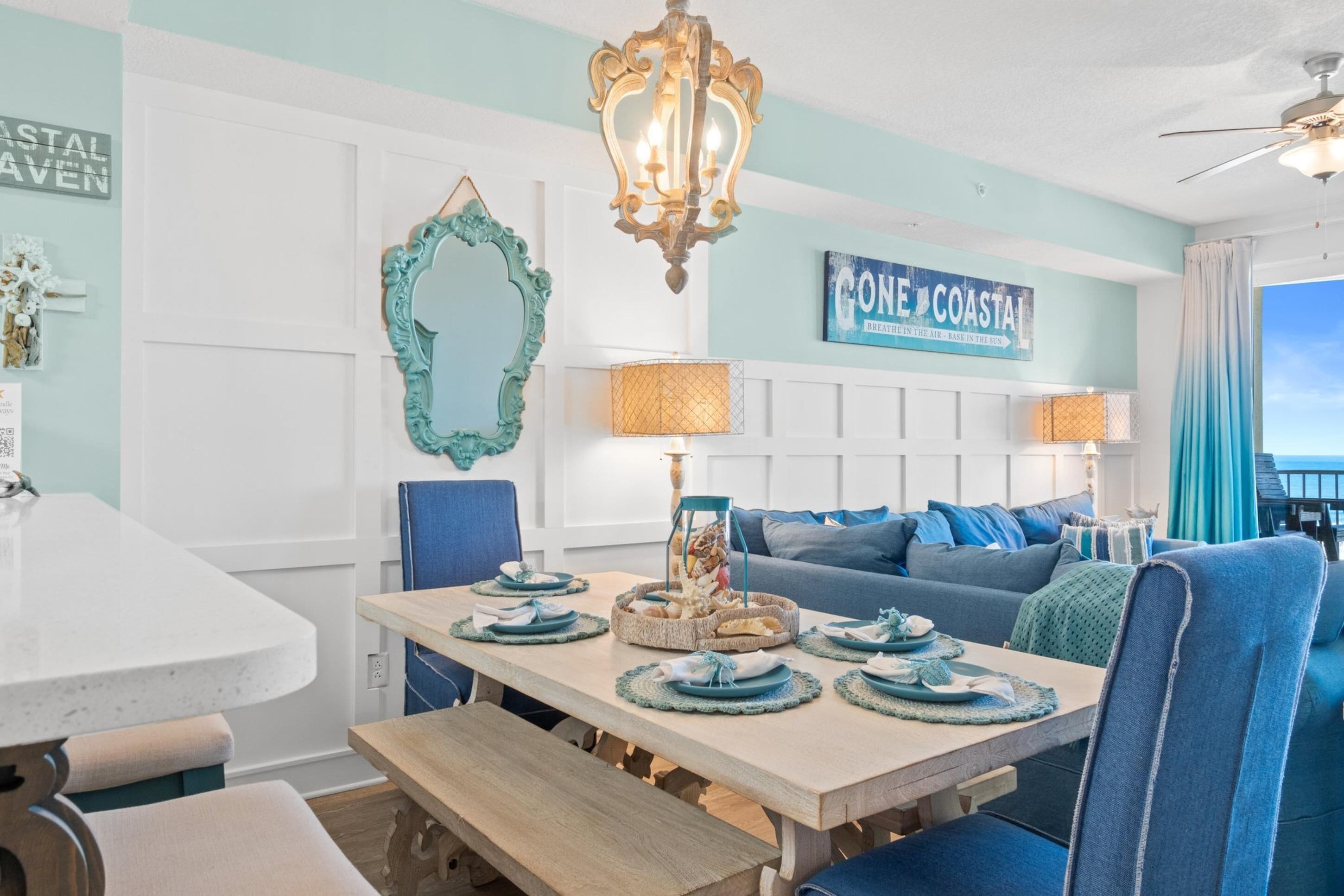 A dining area with a round table, benches, and a blue sofa.