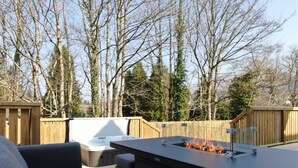 An outdoor patio with a built-in fire feature, a seating area, and a wooden fence.