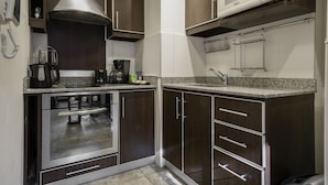A modern kitchen with dark wood cabinets, stainless steel appliances, and a granite countertop. - Loft Premium DE Primer Nivel (Ciudad Autónoma de Buenos Aires, Recoleta)