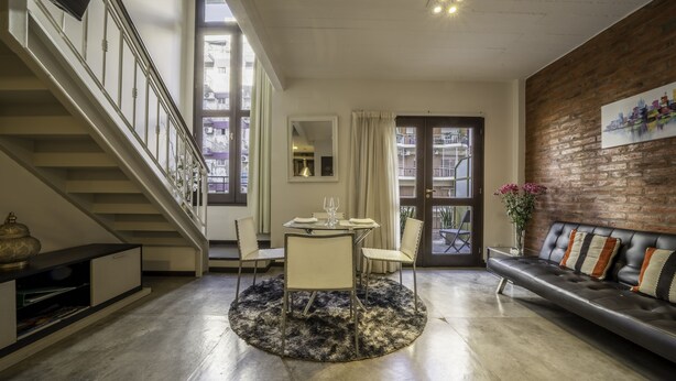A modern living room with a staircase, a dining area, and a sofa. - Loft Premium DE Primer Nivel (Ciudad Autónoma de Buenos Aires, Recoleta)