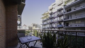A balcony with a table and chairs, surrounded by potted plants. - Loft Premium DE Primer Nivel (Ciudad Autónoma de Buenos Aires, Recoleta)