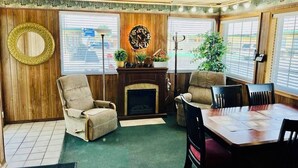 A cozy living room with a fireplace, a dining table, and comfortable seating. - Sage N Sand Motel (Moses Lake)