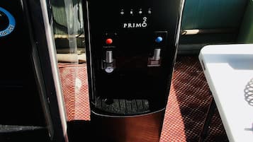A water dispenser with two drink options, a cup holder, and a control panel on a boat deck.