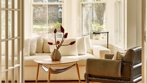 A bright room with a wooden floor, a white sofa, a coffee table, and a leather armchair. - AWOL Kennebunkport (Kennebunkport)