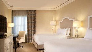 A hotel room with two beds, a desk, a chair, and a television. - EILAN HOTEL & SPA - 1 BR (San Antonio)