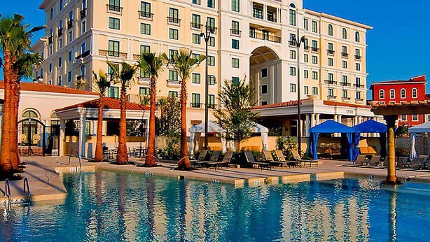 A hotel with a swimming pool, palm trees, and outdoor seating areas. - EILAN HOTEL & SPA - 1 BR (San Antonio)