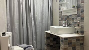 Habitación estándar doble | Baño | Ducha, secador de pelo, toallas y jabón