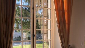 A room with a large window, a radiator below, and a chair with a lamp.