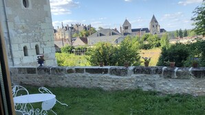 A stone building with a small window and a metal chair outside.