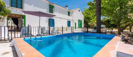 Relax by the serene pool surrounded by a deck and pergola.