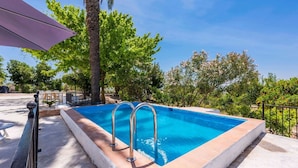 A rectangular swimming pool with metal ladders, surrounded by a white tiled deck and a metal fence. - Cortijo Don Simón Cabra by Ruralidays (Córdoba)