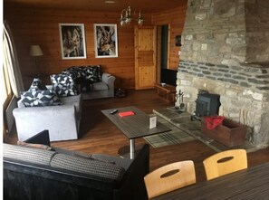 Cozy cabin living area with a sofa, couch, and stone fireplace.