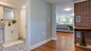 A modern kitchen with white cabinets, a black faucet, and a patterned backsplash. - Lakefront home, water-view porch (Dedham)