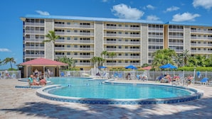 A hotel with a large pool area, multiple balconies, and a view of the ocean. - Oceanfront Bonita Beach Condo w/ Pool Access! (Bonita Springs)