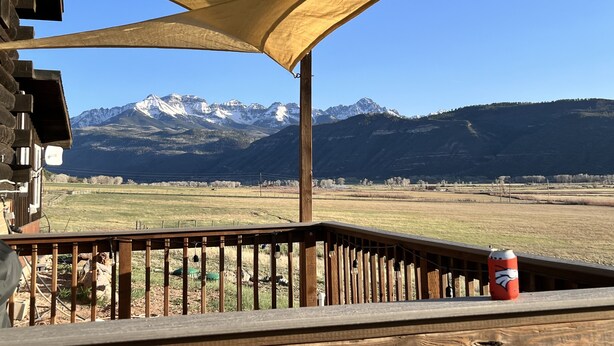 A wooden deck with a view of snow-capped mountains.